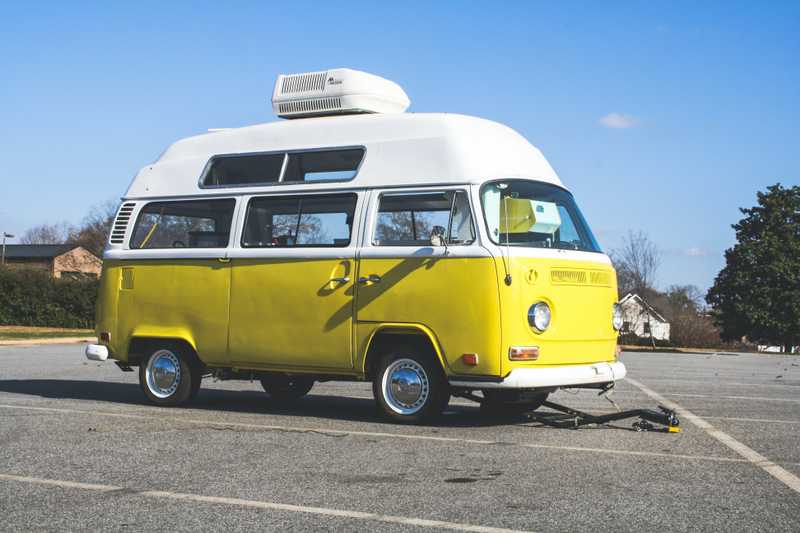 A yellow and white Volkswagen van parked in a parking lot. According to the photographer, this van was retrofitted as a mobile creperie and coffee house.