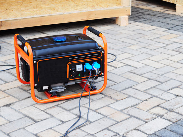 A gas powered portable generator that is plugged into a bounce house blower