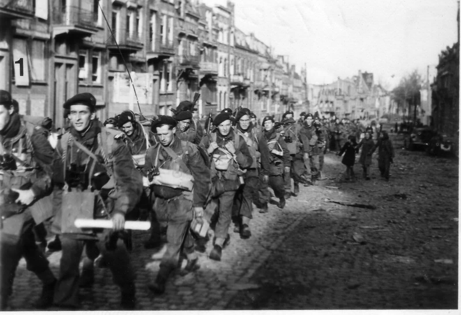 Le lieutenant de Montlaur (1er rang à gauche, les cartes à la main) et les commandos français défilent dans les rues de Flessingue (Coosjie Buskenstraat, île de Walcheren, Pays-Bas), le 3 novembre 1944. Ils sont en route pour la ville de Domburg, au nord-ouest de l'île. La photo a été prise par le reporter du Daily Sketch et publiée dans ce journal le 8 novembre.