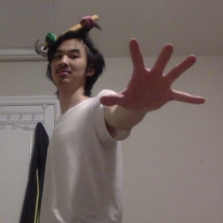 Ching Chang with a hammer tied into his hair doing the vibe check hand