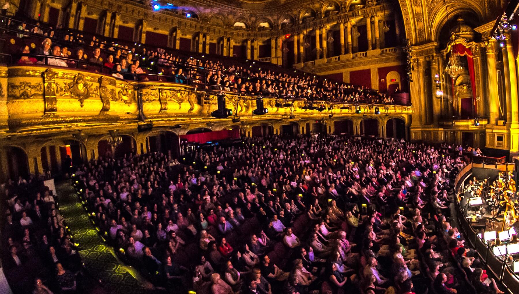 An audience watches a performance in the Boston Opera House auditorium.