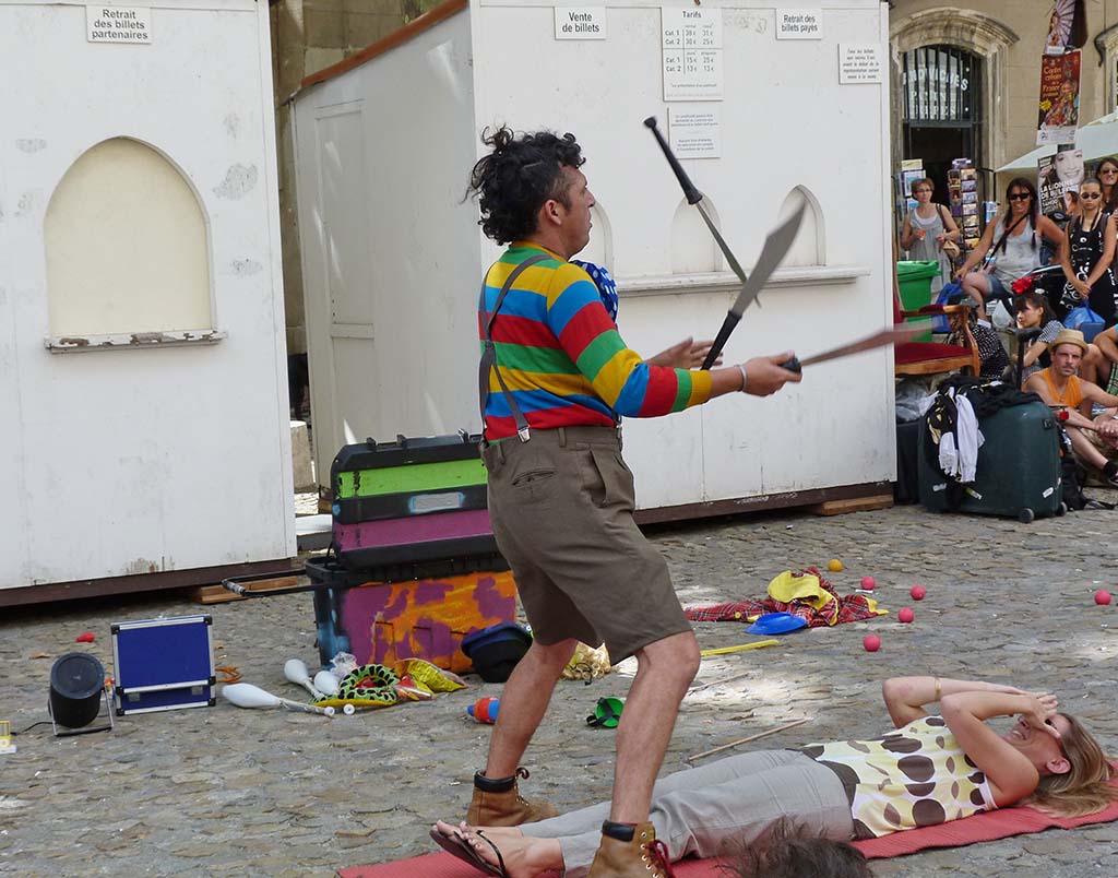 A juggler juggles large knives