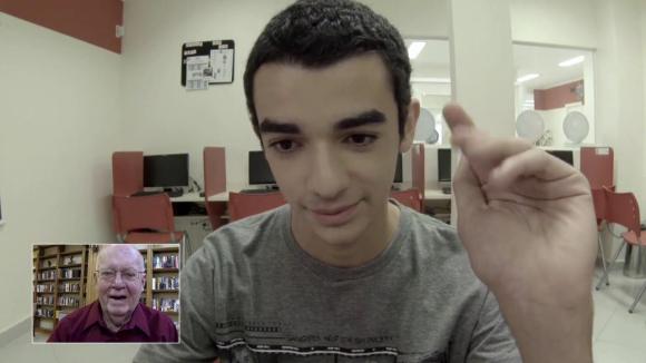 screenshot of a teenager using a skype-like application with his elder English-speaking partner in a thumbnail screen in the corner