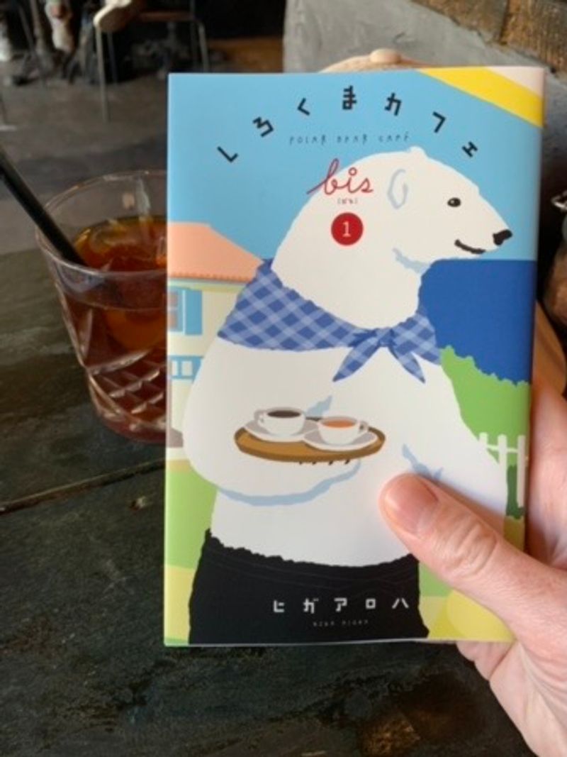 The first book of shirokuma cafe (in Japanese). Beside the book is an iced coffee.