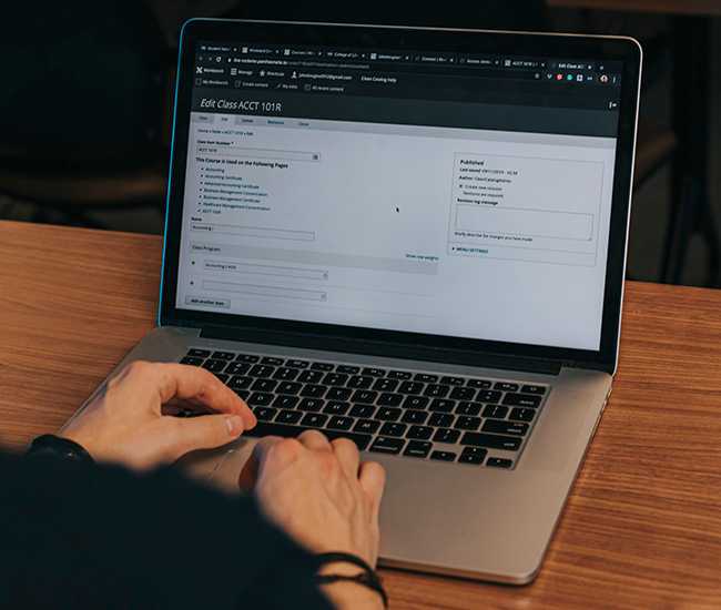 Faculty using syllabus management software on a laptop.