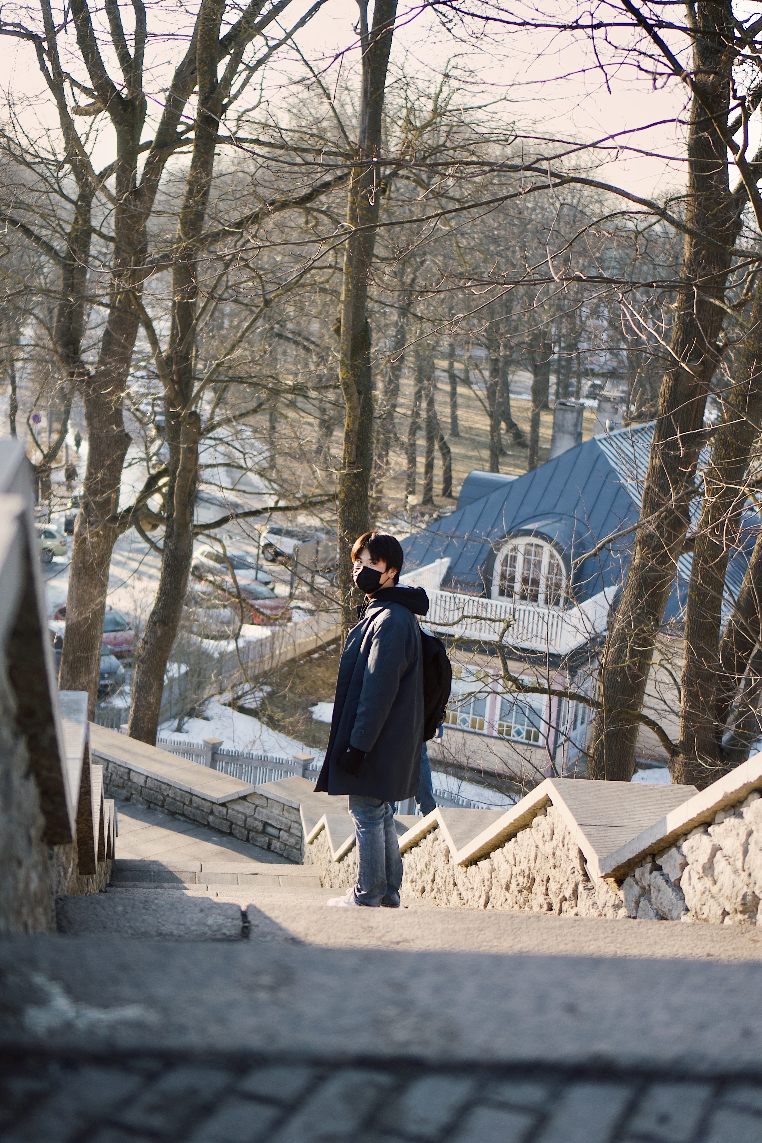 Image of Allen, an Asian man in black jacket, standing on a stairs in Tallinn, Estonia