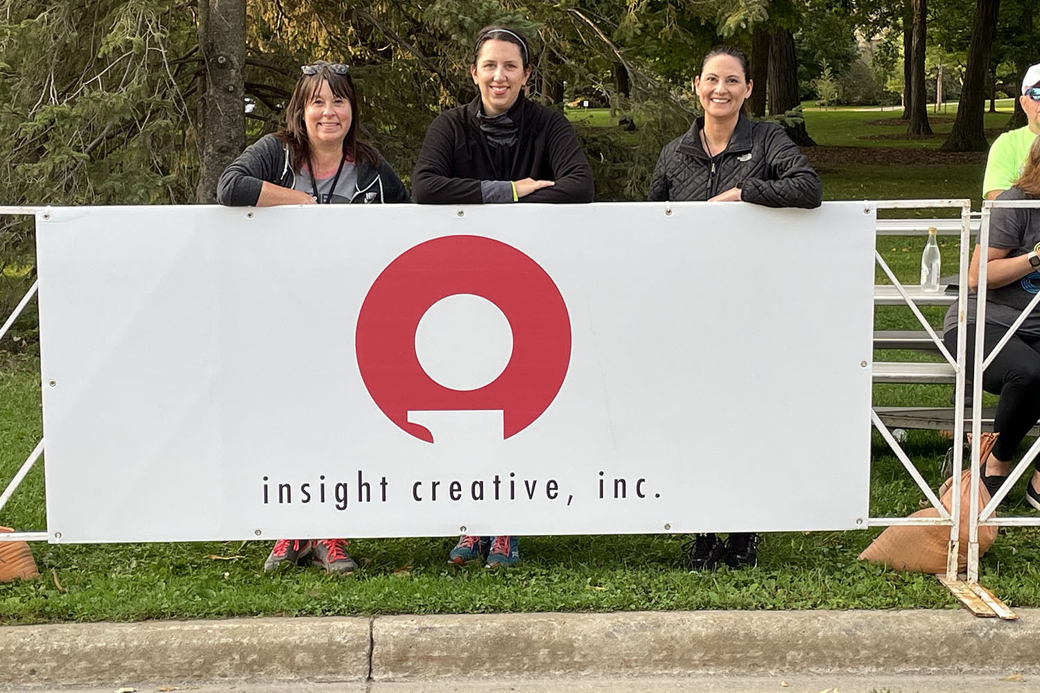 Insight Creative event marketing team standing behind the Insight Creative sign at the Fox Cities Marathon
