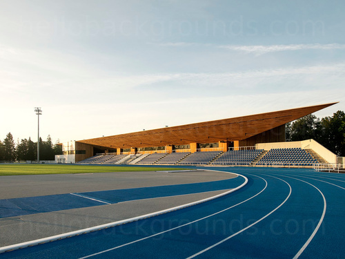 Running track with blue running lanes and spectator stadium seating Skype background