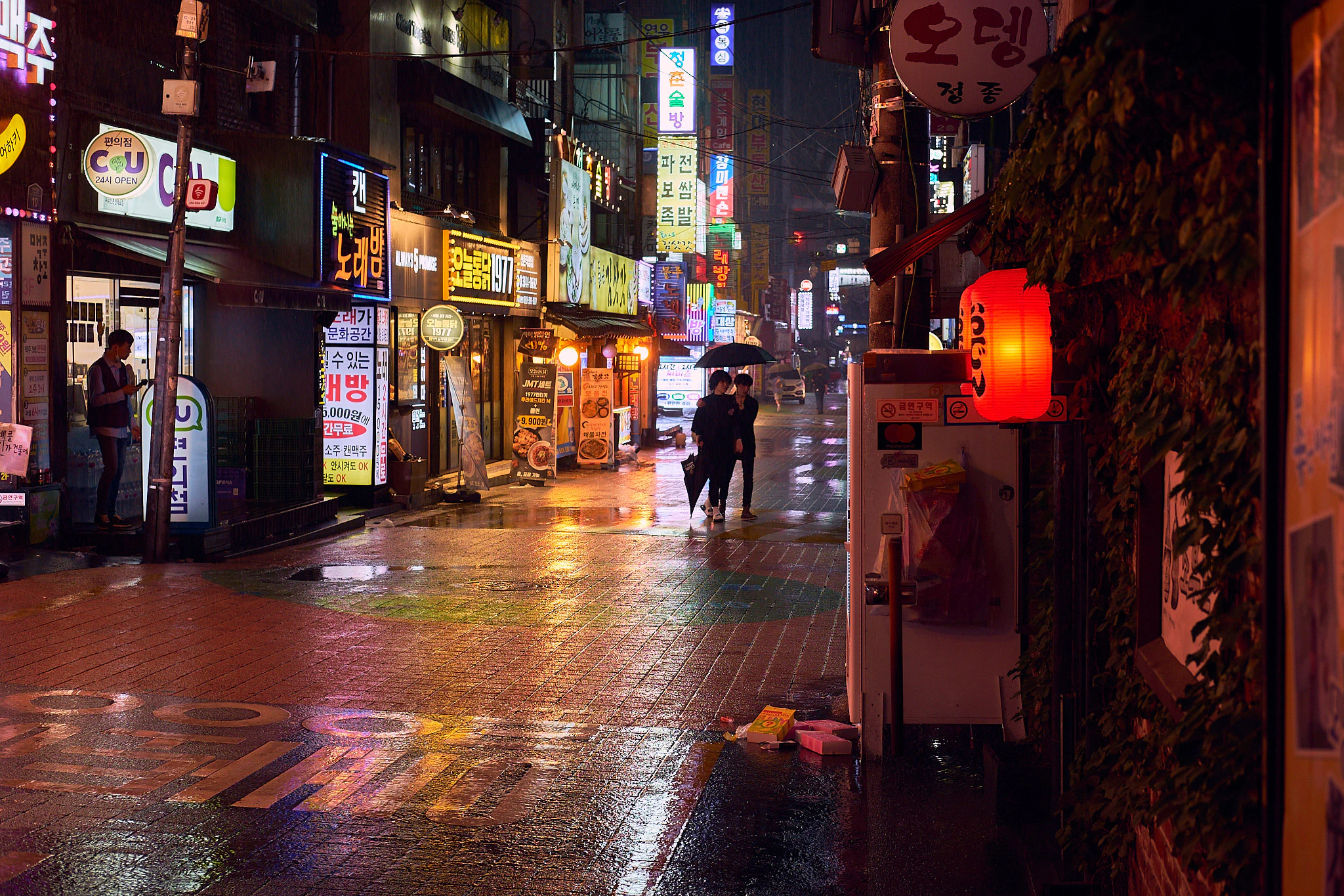 A picture of a rainy street at night in Sinchon, Seoul.