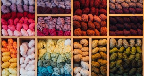 Thumbnail Spools of yarn in a variety of colors neatly stacked