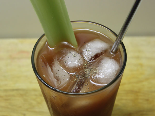 A top down look at a garnished Bloody Mary with black pepper