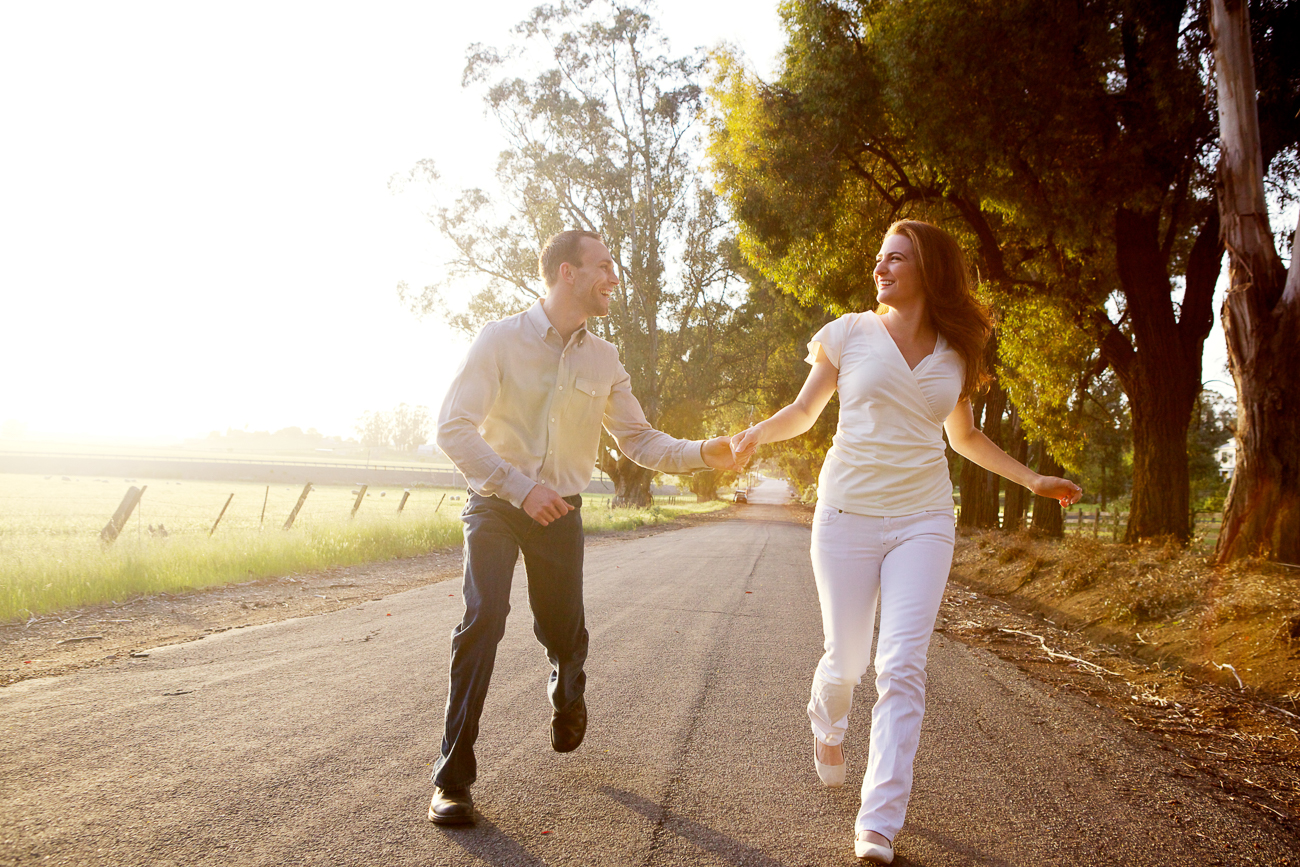 a young couple happily running together at sunset