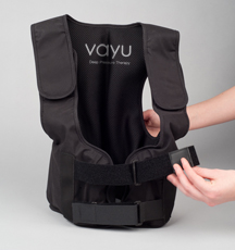 a black nylon vest, with plastic snap attachments across the front and a black personal pump attachment, akin to a blood pressure measure.