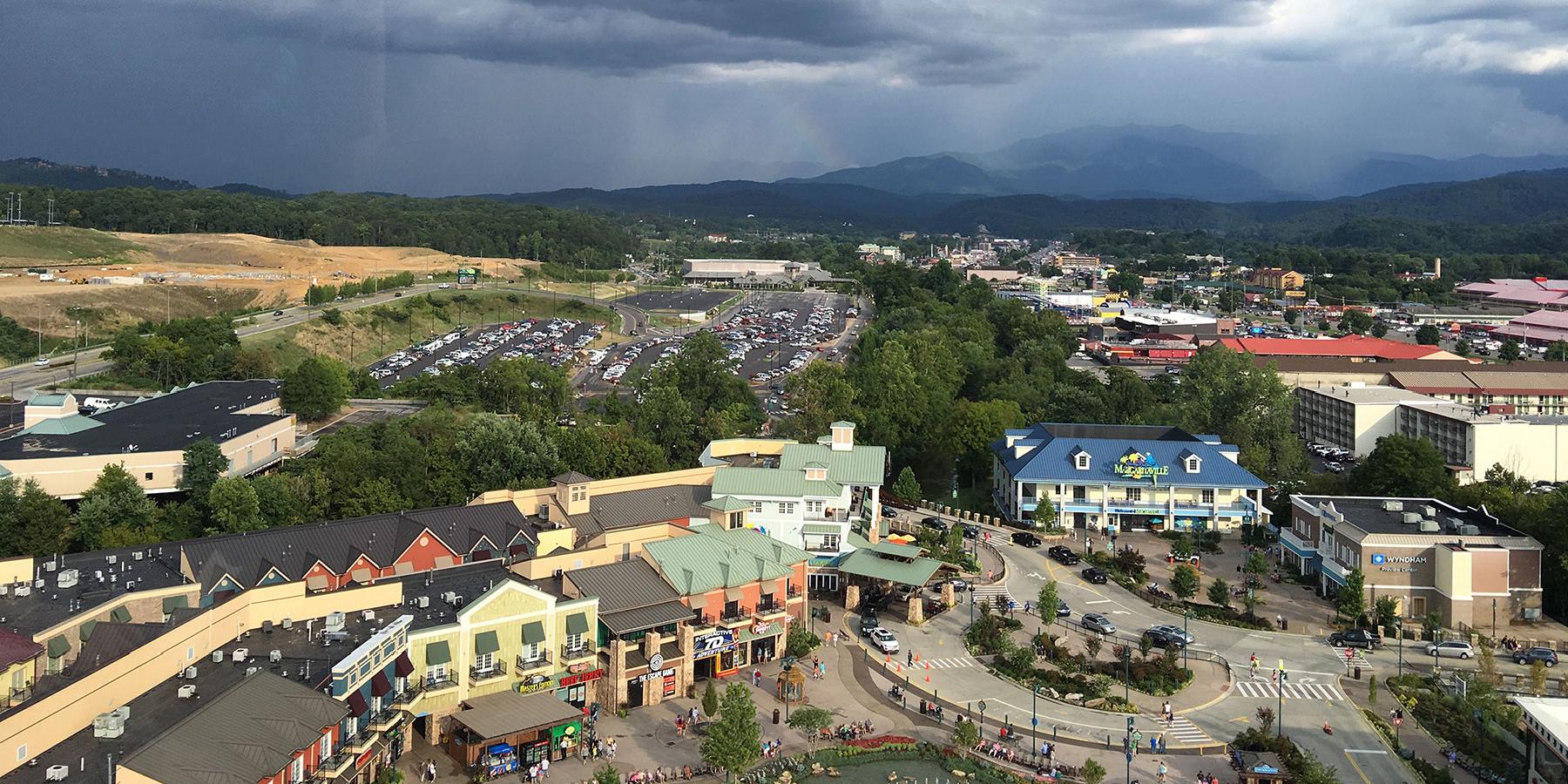 Arial view of a modern shopping complex with dark clouds in the distance.