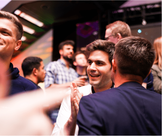 Group of smartly dressed men standing together at some kind of party event.