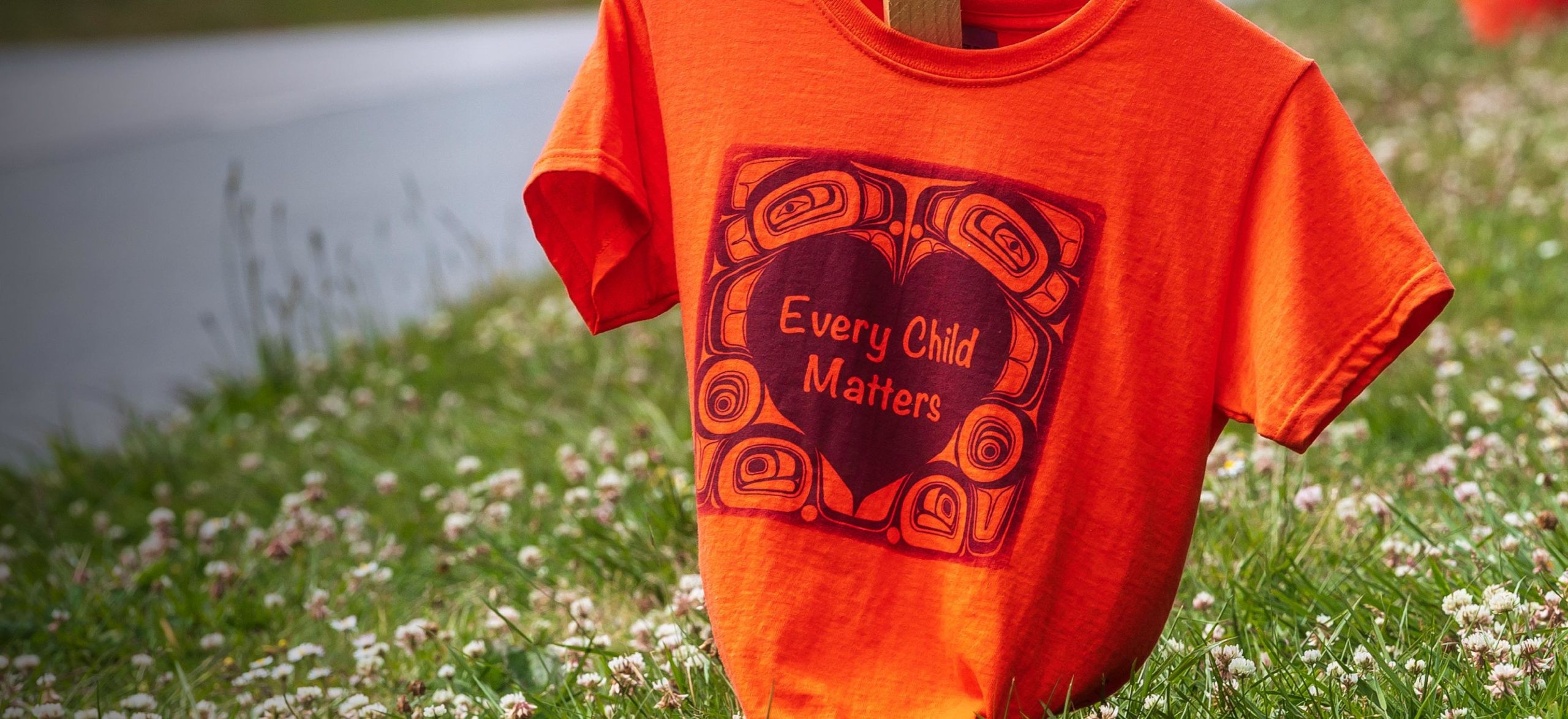 Orange shirts with the phrase &quot;Every Child Matters&quot; printed on them line Marine Drive in Vancouver as a memorial for the Indigenous children who were sent to residential schools in Canada. 