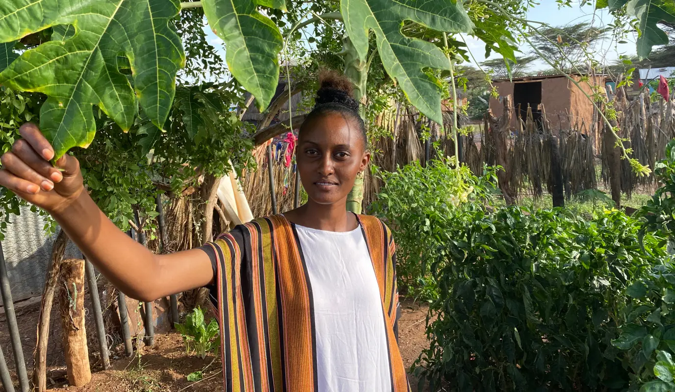 Robe under a papaya tree in her mother, Iladho's kitchen garden in Kalacha.