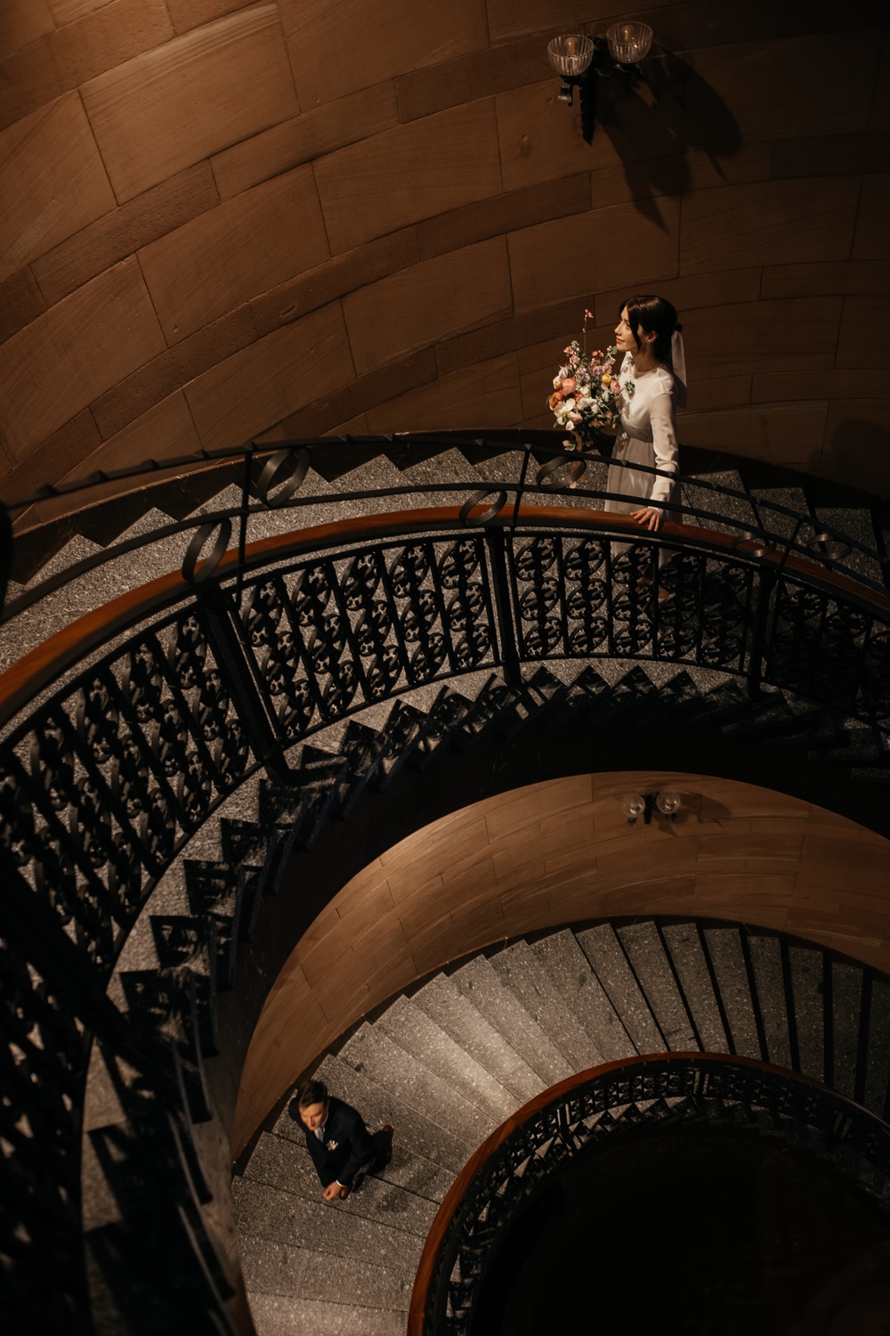 Zdjęcia ślubne Poznań - para młoda wchodząca po krętych schodach - zdjęcie w kolorze