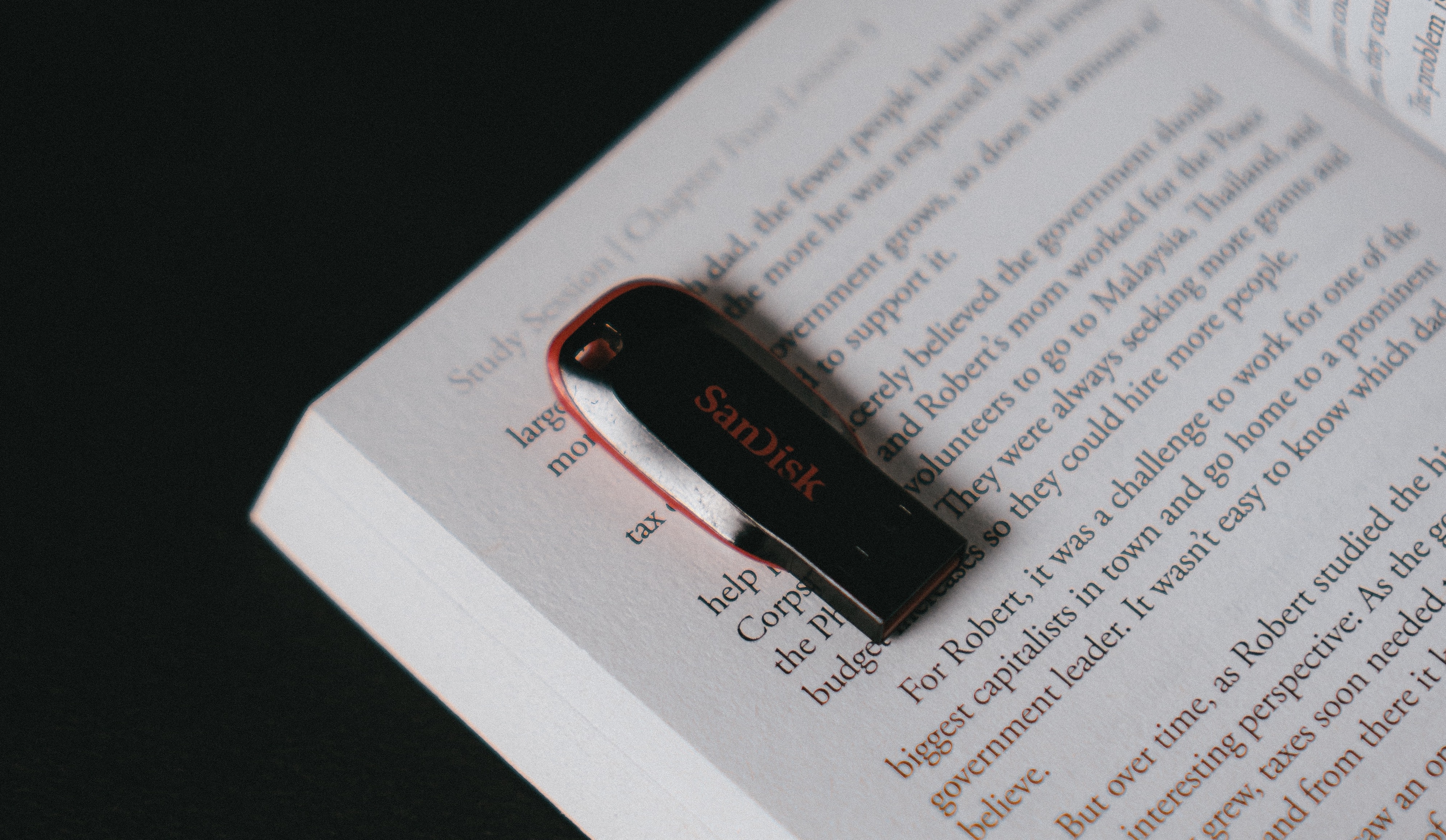 A USB flash drive rests on an open book.