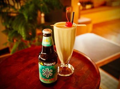 Bottle of Pyramid Snow Cap next to ice cream shake beer cocktail on a small table