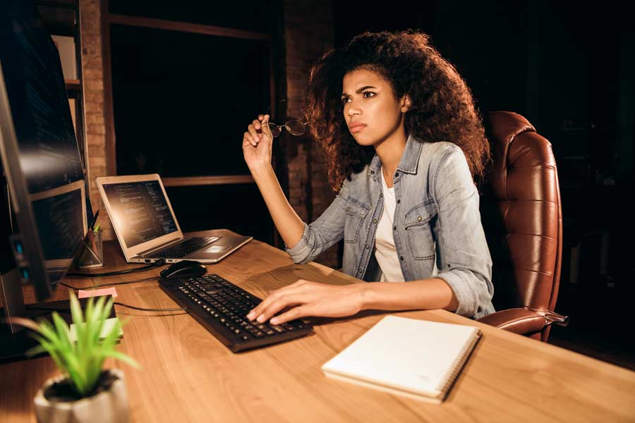Woman staring frustratedly at a screen where her website is down due to a DDoS attack.