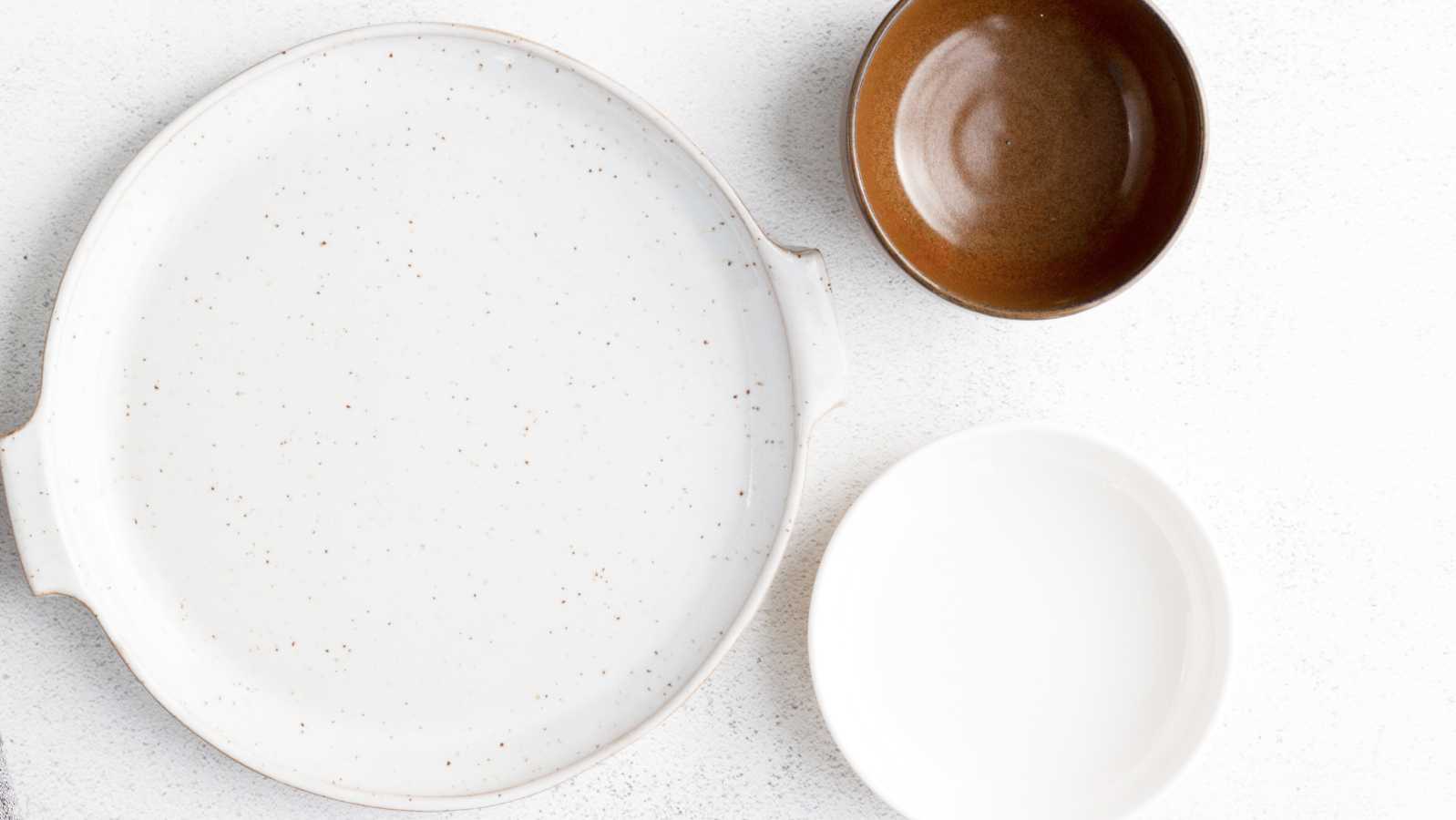This is the Partnerships background image. On the right-hand side is one large white with small brown splatters, and on the top left is a small brown bowl and directly below is a white bowl. 
