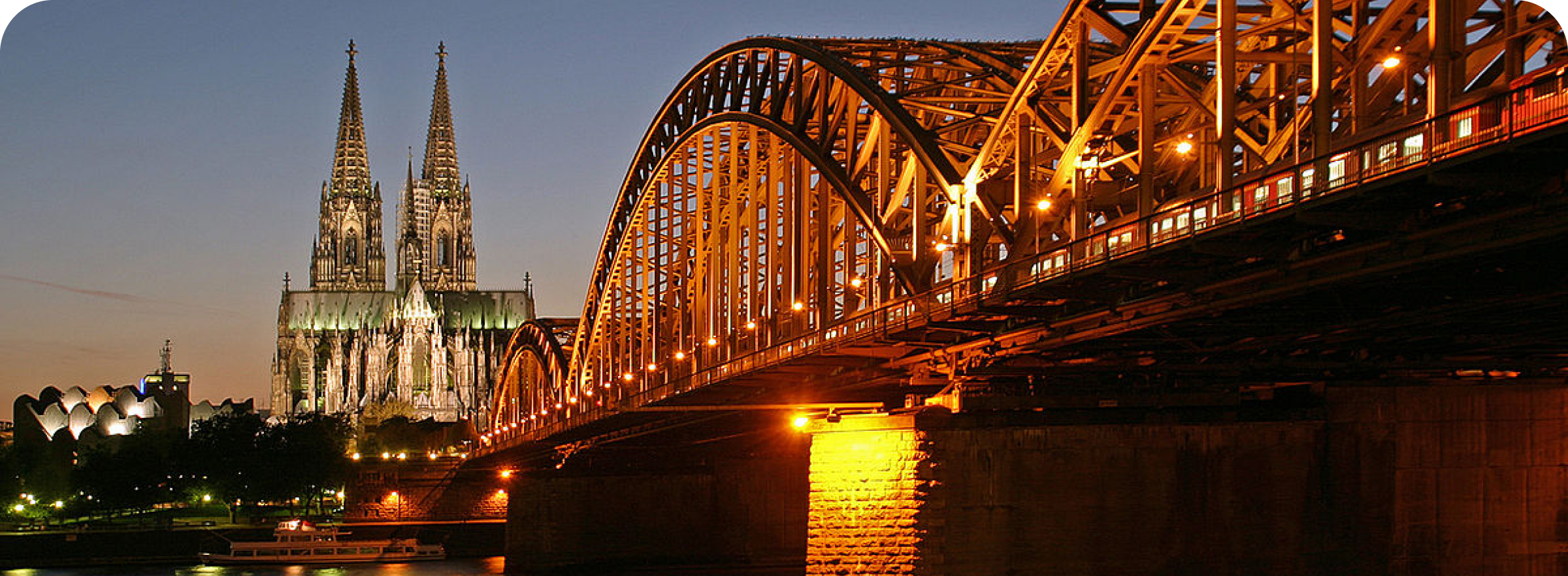 Rhein Energie cover image of an evening view in the city of Cologne, featuring a church and bridge.