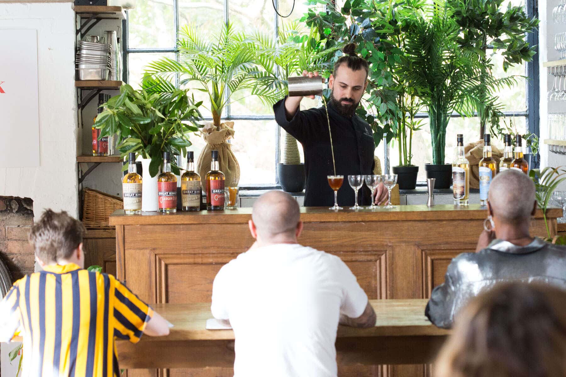 a bartender pouring a cocktail drink from height