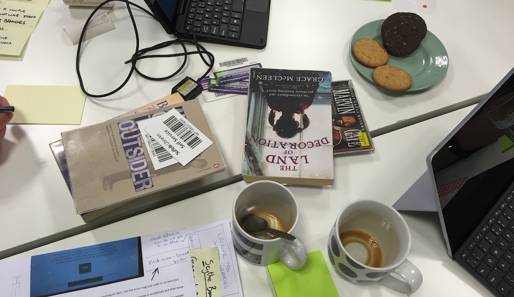 Empty coffee cups, tablets, books and barcode scanners on a table
