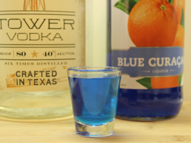 Half a shot of Vodka and Blue Curacao in a shot glass
