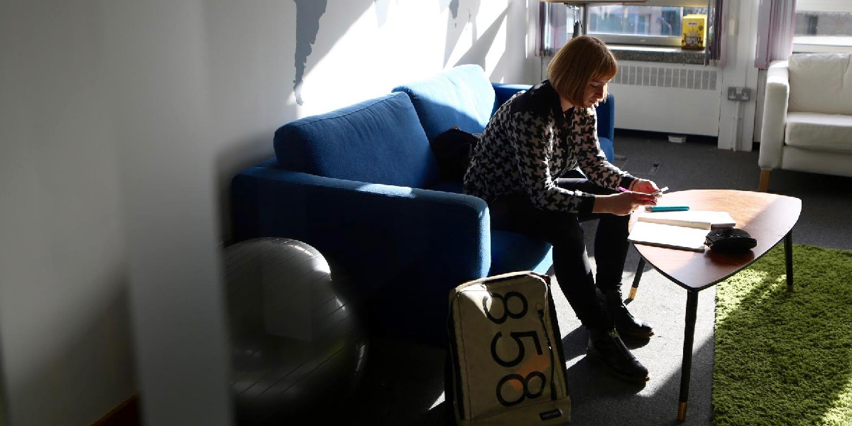 UX designer Alex Humphry-Baker scrolling through her favourite mobile app UX designer Alex Humphry-Baker sitting on a sofa, scrolling through her mobile phone