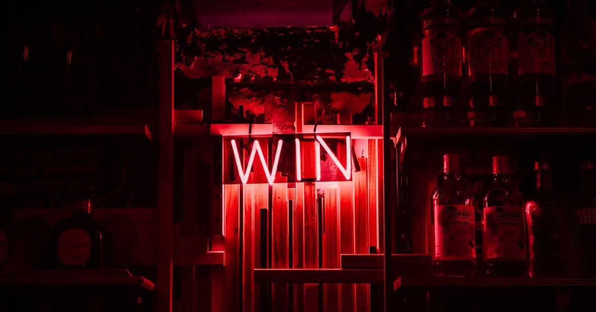 Der Schriftzug "WIN", dargestellt aus rot leuchtenden Neonröhren.