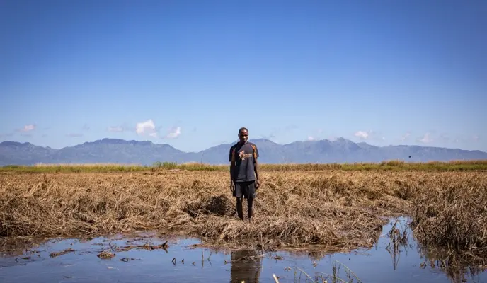 Recently married Patrick Ghembo of Monyo Village, Malawi, standing in his field, destroyed by the floods.