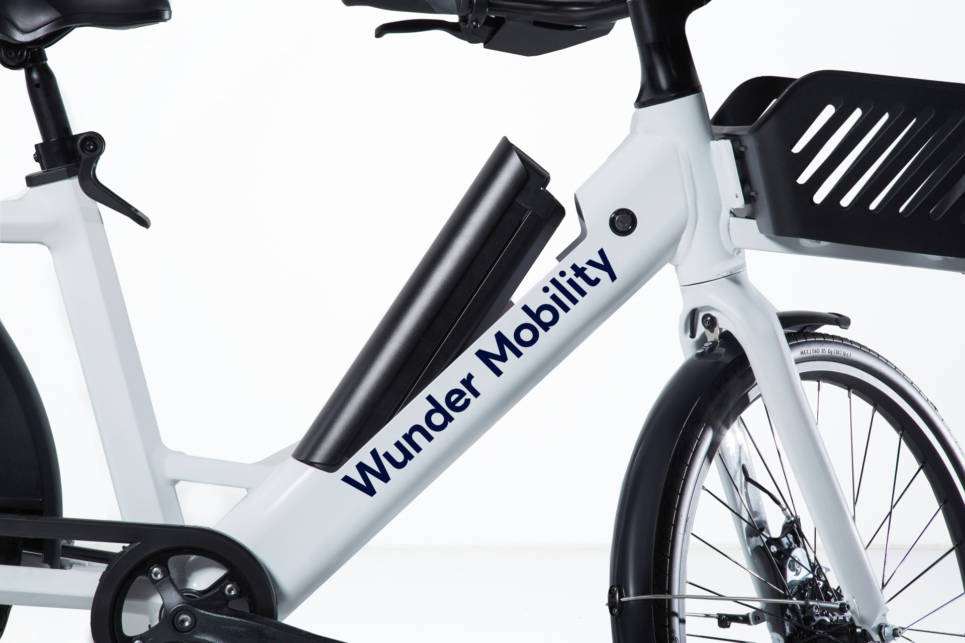 Side view image of the Wunder e-bike and the uplifted battery, and basket in front.