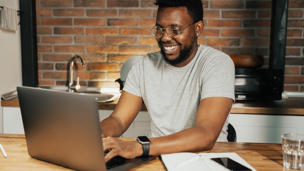 Happy male business founder using a laptop