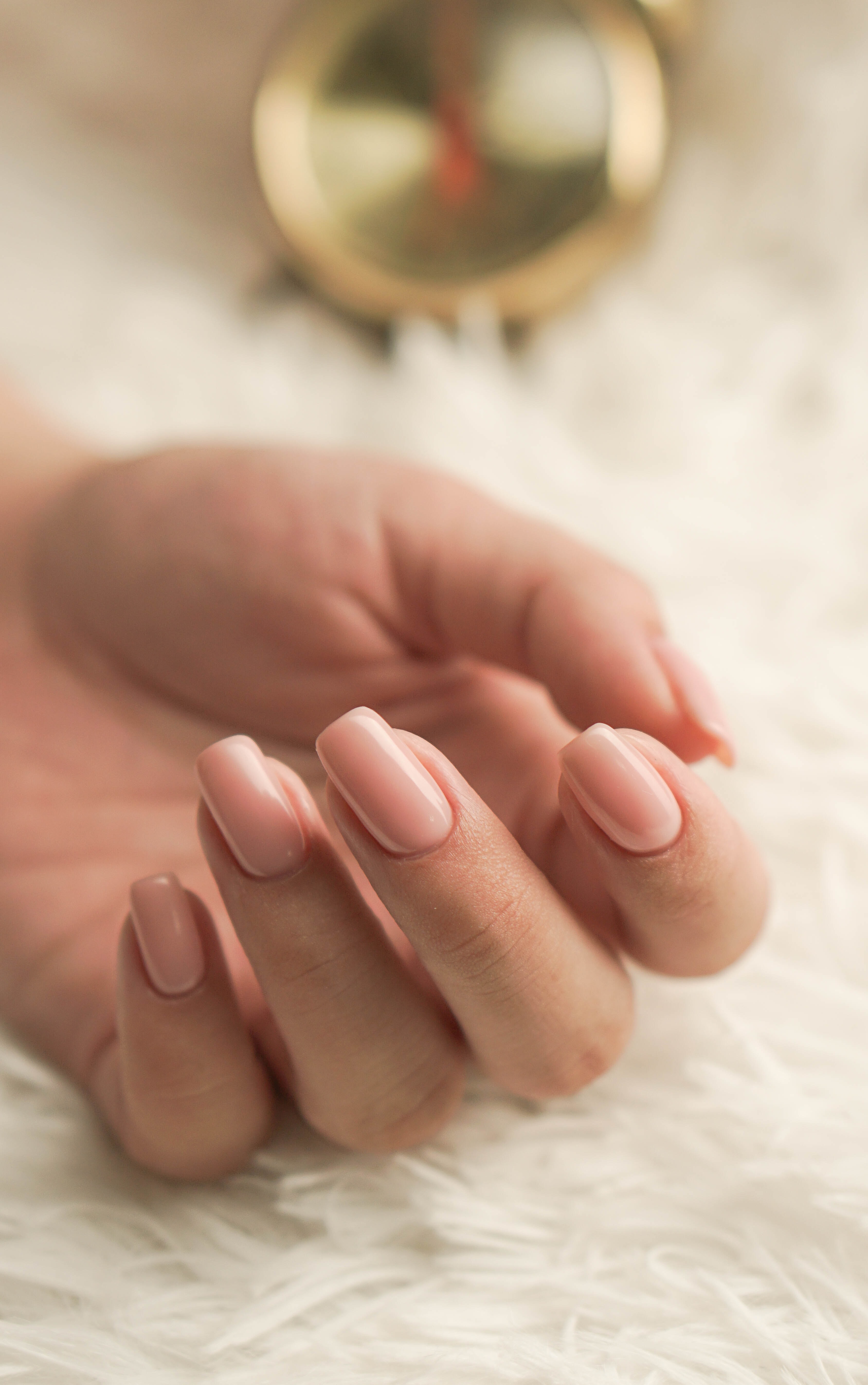 Mão de mulher com unhas tratadas com verniz gel