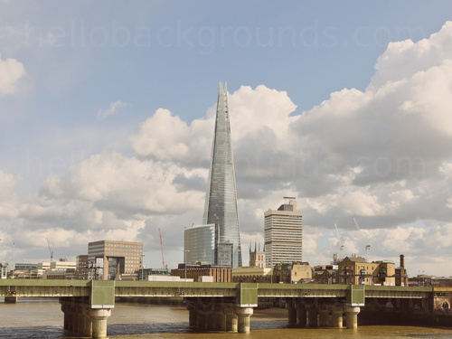 Urban London riverside view of the The Shard building against partially cloudy sky with green and white bridge in front Zoom background