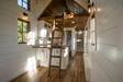 Timbercraft Tiny Homes' Denali gooseneck tiny house; a full view of the kitchen, along with the six-step staircase to the master bedroom and a ladder to a storage/space-bedroom loft space. Timbercraft Tiny Homes' Denali gooseneck tiny house; a full view of the kitchen, along with the six-step staircase to the master bedroom and a ladder to a storage/space-bedroom loft space.