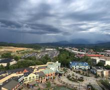 Arial view of a modern shopping complex with dark clouds in the distance.