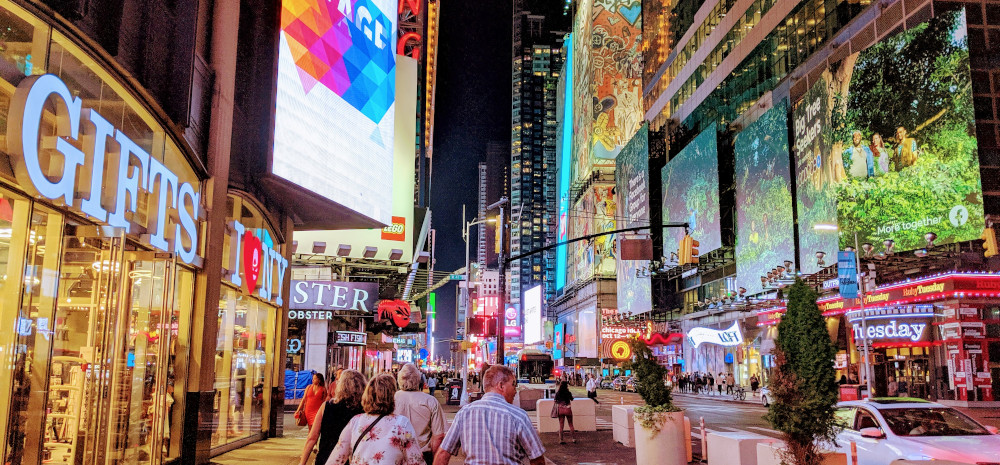 An image of Times Square in New York City at night. It is very chaotic
