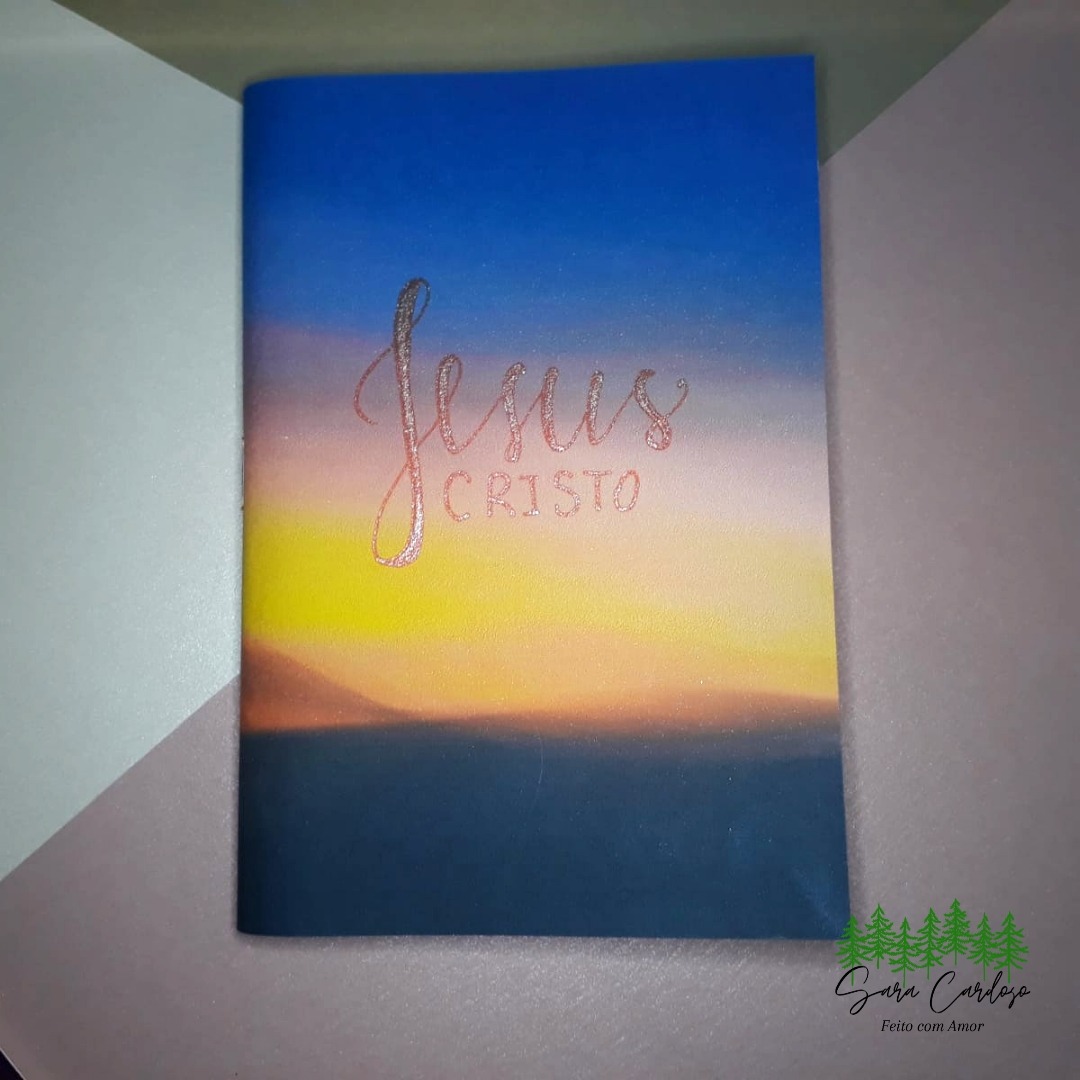 Caderno A6 com 50 folhas de papel reciclado, capa de paisagem do horizonte com O Nome Jesus e acabamento em grampo