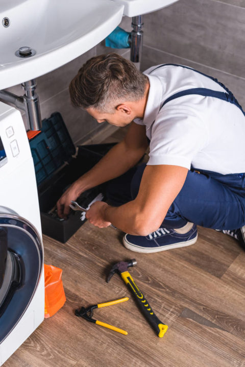 repairman sitting on floor and taking repair tools from box