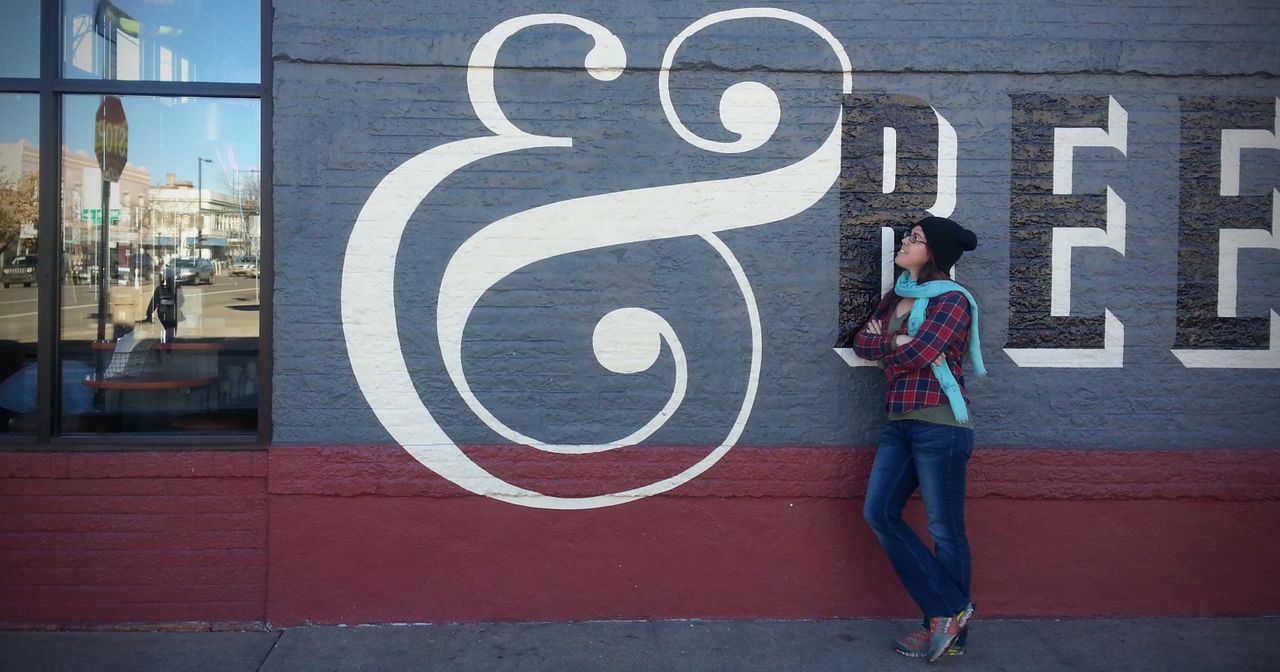 Sondra looks at large ampersand symbol painted on building exterior