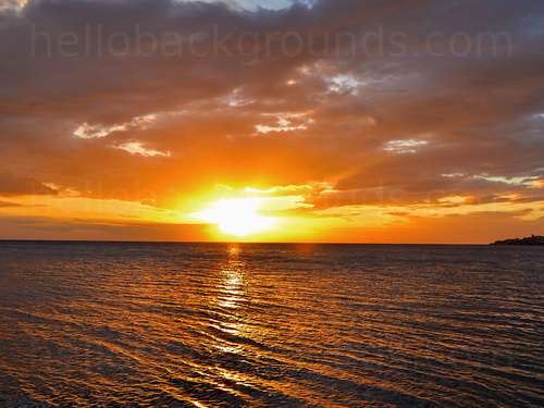 Sunset over the ocean with cloudy skies Skype background