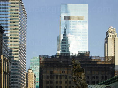 Urban cityscape featuring multiple office buildings of various styles with sunlight and building reflecting in windows Microsoft Teams background