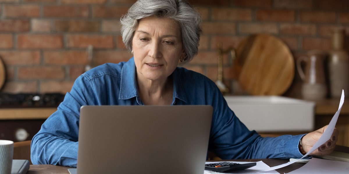 How to use the COUNTIFS function in Excel A data analyst sitting at a desk with a brick wall behind them, looking at a laptop screen, holding a piece of paper in their hand