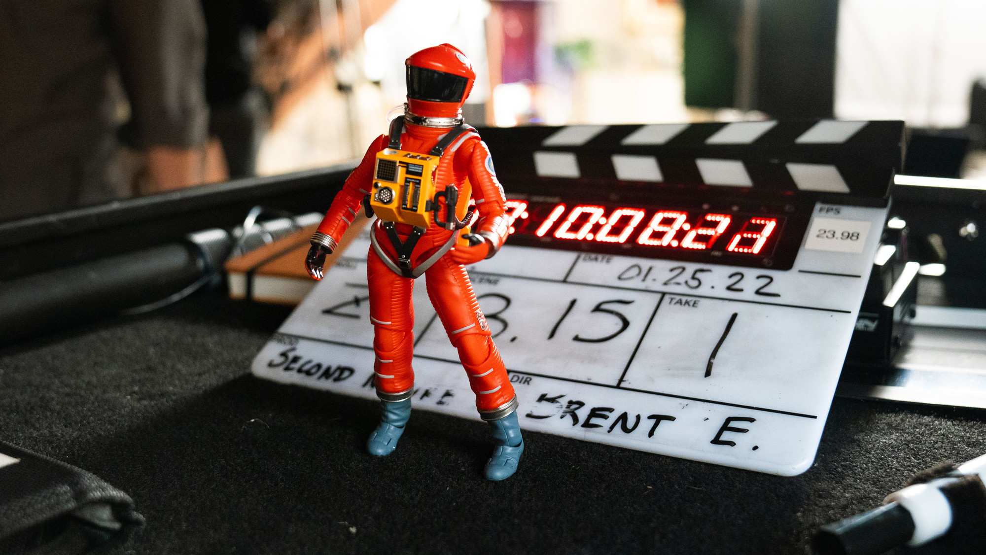 An astronaut figurine in front of a clapperboard