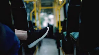 Feet hanging over the edge of a seat in a bus