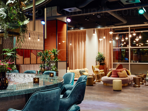 Bar interior featuring artistic decoration with blue marble bar and colour matching stools in front of padded seating Skype background