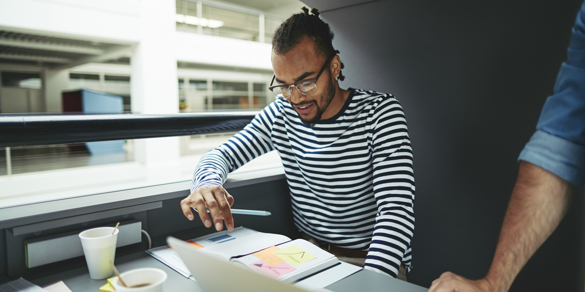 UI designer choosing the right font for his website UI designer sitting down and choosing a font with his laptop and some notes